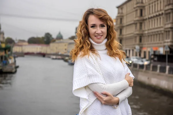 Smuk kvinde i hvid sweater på dæmningen - Stock-foto