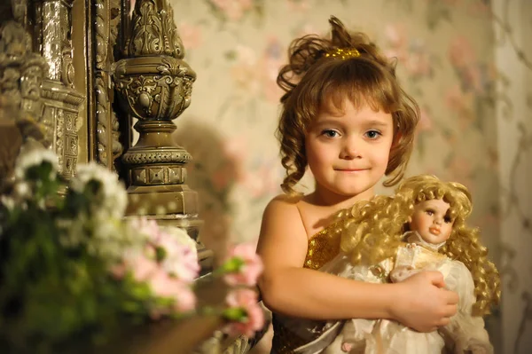 Portrait of a little girl with a retro doll in her hands — Stock Photo, Image