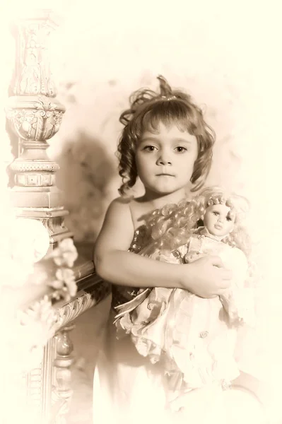Retrato de uma menina com uma boneca retro em suas mãos — Fotografia de Stock