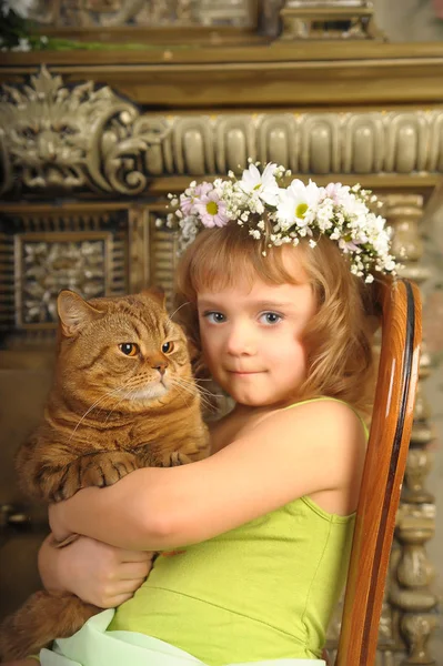 Bambina seduta con una corona di fiori in testa con un — Foto Stock