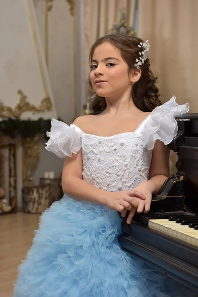 Κορίτσι νεαρή πριγκίπισσα σε λευκό με ένα μπλε φόρεμα και ένα μπακέτα σε — Φωτογραφία Αρχείου