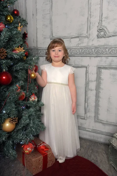 Chica en los puestos de vestir junto al árbol de Navidad — Foto de Stock