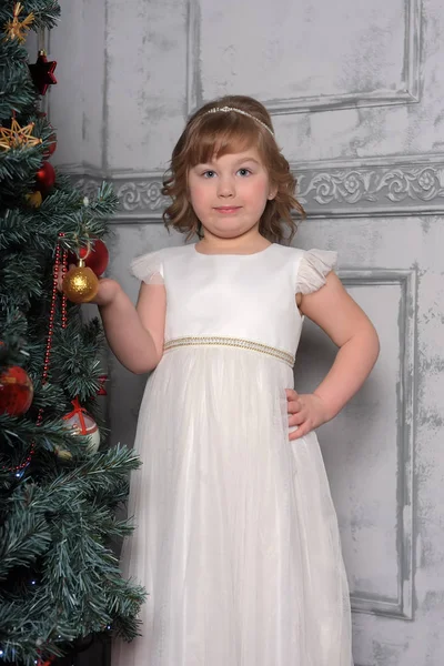 Chica en los puestos de vestir junto al árbol de Navidad — Foto de Stock