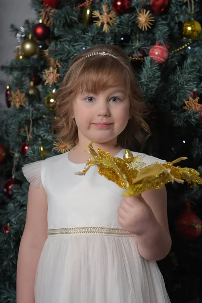 Uma menina em um vestido branco com uma expressão facial engraçada e um grande — Fotografia de Stock