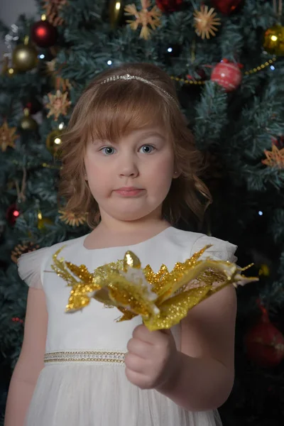 Uma menina em um vestido branco com uma expressão facial engraçada e um grande — Fotografia de Stock