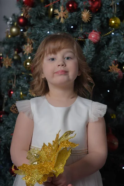 Uma menina em um vestido branco com uma expressão facial engraçada e um grande — Fotografia de Stock