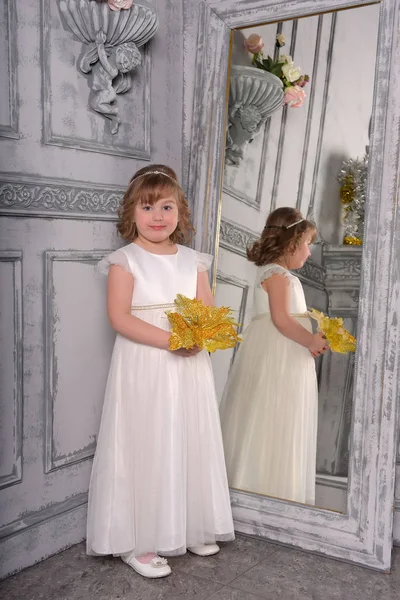 A girl in a white dress with a funny facial expression and a big — Stock Photo, Image