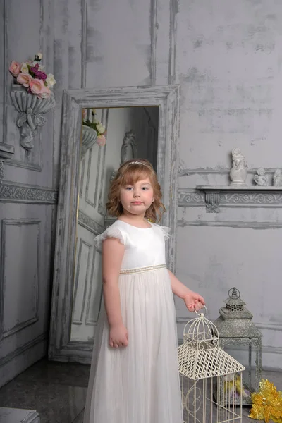 鳥かごの近くに白いドレスを着た小さな女の子 — ストック写真