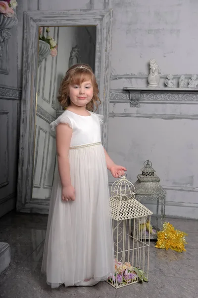 Little girl with white dress near bird cage — Stock Photo, Image