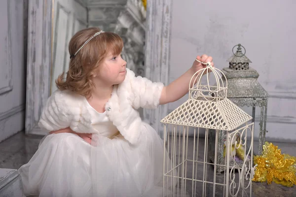 花とセルの近くに白いドレスを持つ小さな女の子 — ストック写真