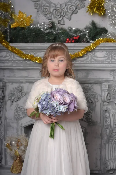 Een meisje in een witte jurk en een bontjas met een bruiloft boeket in — Stockfoto