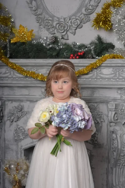 Uma menina em um vestido branco e um casaco de pele com um buquê de casamento em — Fotografia de Stock