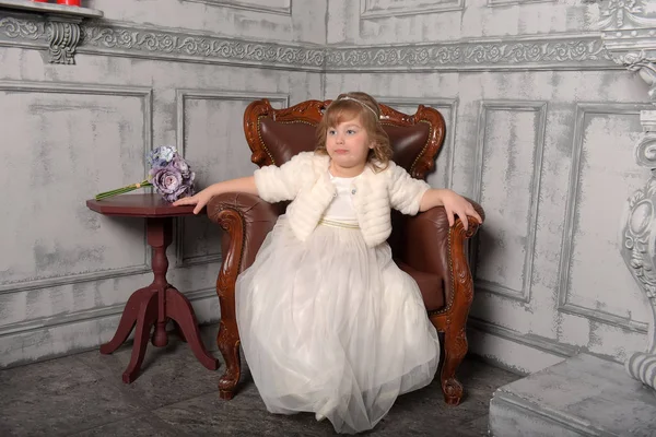 Dziewczyna w białej sukni i sierść siedzi — Zdjęcie stockowe