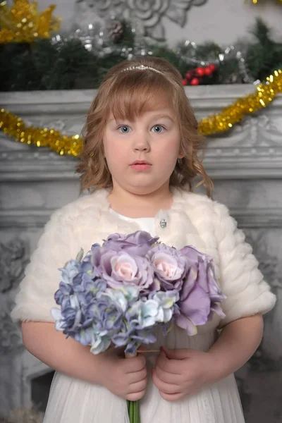 Uma menina em um vestido branco e um casaco de pele com um buquê de casamento em — Fotografia de Stock