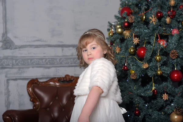 Uma menina em um vestido branco e um casaco de pele está girando em um dr branco — Fotografia de Stock