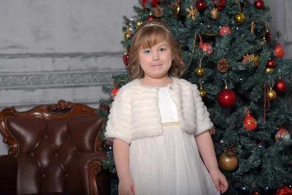 Uma menina em um vestido branco e um casaco de pele está girando em um dr branco — Fotografia de Stock