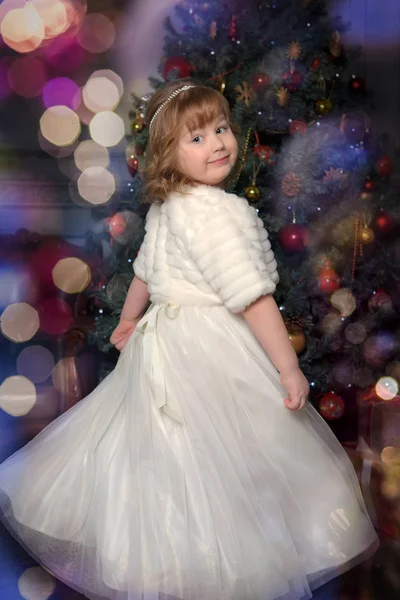 Uma menina em um vestido branco e um casaco de pele está girando em um dr branco — Fotografia de Stock