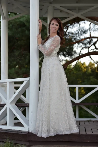 A woman in a white dress in the park at the gazebo — Stock Photo, Image