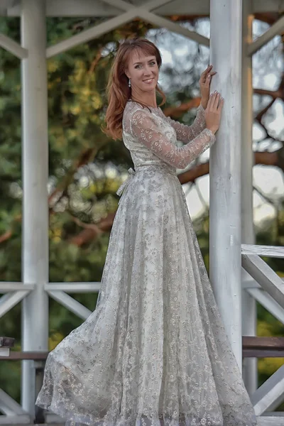 Una donna vestita di bianco nel parco al gazebo — Foto Stock