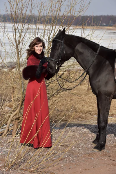 Woman in a red long dress with a horse in nature — 스톡 사진