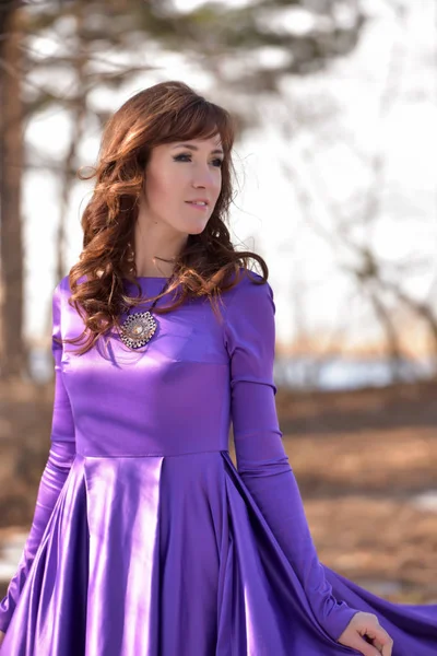 Vacker brunett kvinna i lila lång klänning. Elegans, vuxen. — Stockfoto