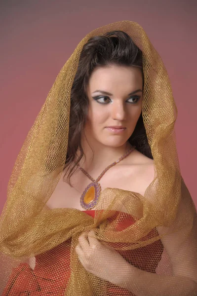 Ritratto di una bella donna bruna in un mantello d'oro — Foto Stock