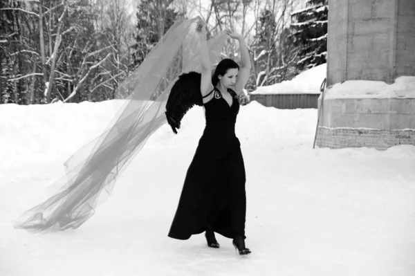 Menina com asas de anjo preto em um vestido preto no inverno e vermelho f — Fotografia de Stock