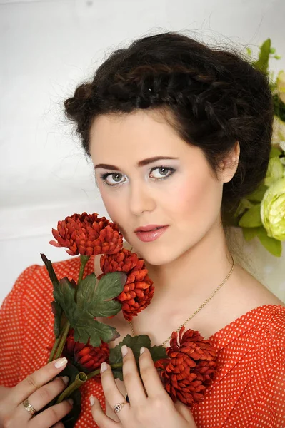 Portrait of l brunette with red flowers — Stock Photo, Image
