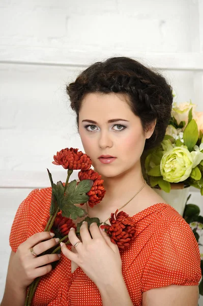 Portrait of l brunette with red flowers — Stock Photo, Image