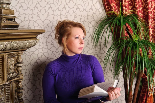 Woman sits on a studio in a retro interior and reads — Stock Photo, Image