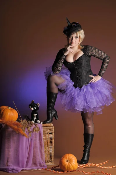 Blond met een pompoen in de studio en een speelgoed zwarte kat, Hallowe — Stockfoto
