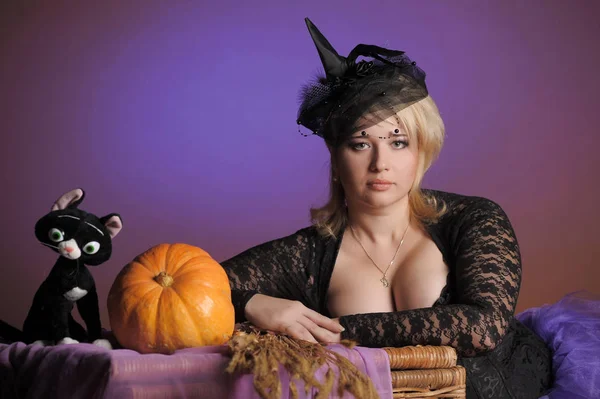Blonde with a pumpkin in the studio and a toy black cat, Hallowe — 스톡 사진