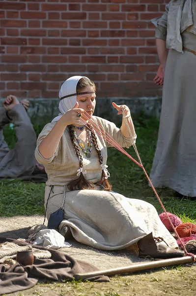 Uma mulher em um traje medieval está envolvida em bordado para o h — Fotografia de Stock
