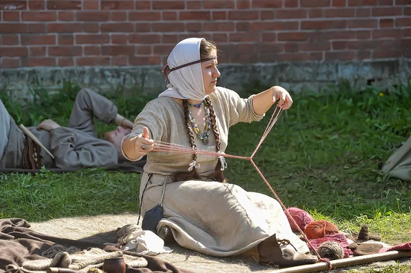 Una donna in costume medievale è impegnata in cucito per la h — Foto Stock