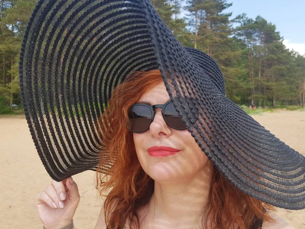 Mulher em um chapéu de abas largas preto e óculos de sol retrato — Fotografia de Stock