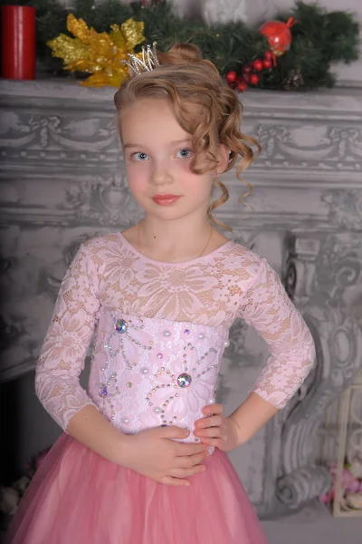 Young girl in a pink dress by the fireplace — Stock Photo, Image