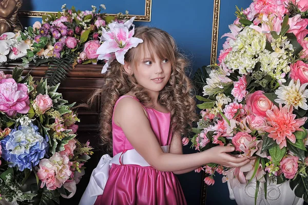 小女孩在粉红色的公主礼服之间的鲜花在圣 — 图库照片