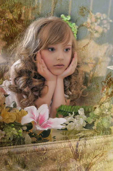 Portrait of a cute girl with curls among flowers — Stock Photo, Image