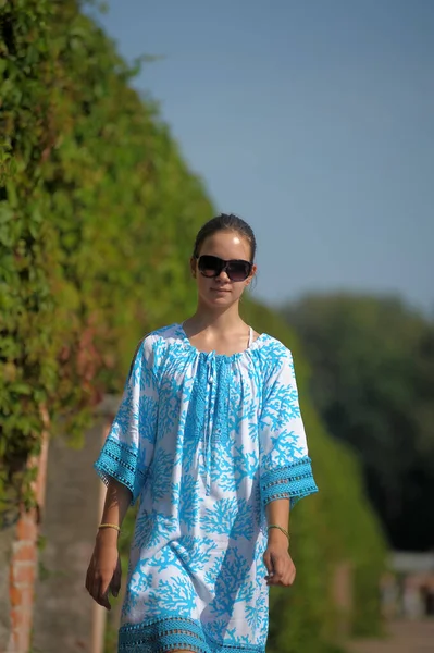 在公园里 年轻的少女穿着蓝色的衣服 戴着太阳镜 — 图库照片