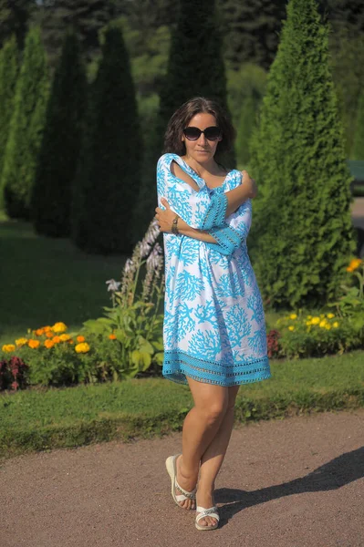 夏天穿着蓝色衣服戴太阳镜的年轻女子在公园里 — 图库照片