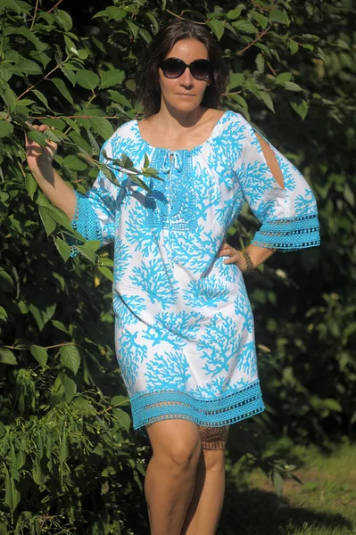 Yazın Parkta Mavi Elbiseli Güneş Gözlüklü Genç Bir Kadın — Stok fotoğraf