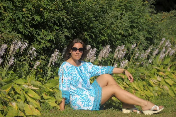 Fiatal Kék Ruhában Napszemüvegben Nyáron Parkban Virágoskert Közelében — Stock Fotó