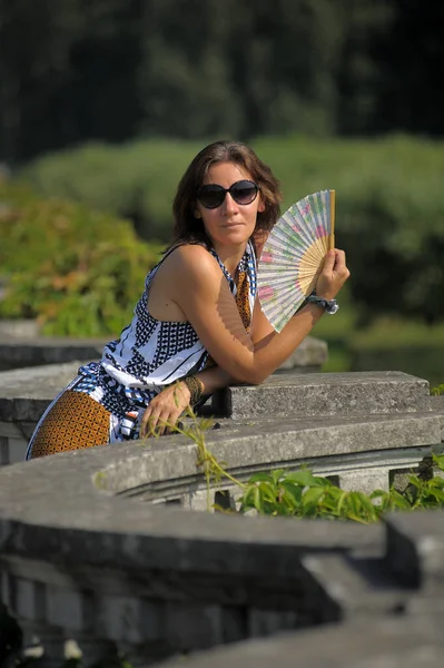 Vrouw Een Hete Dag Zonnebril Met Een Ventilator Haar Handen — Stockfoto