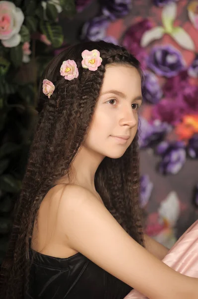 少女黑发肖像画 花朵背景下的玫瑰样式 — 图库照片