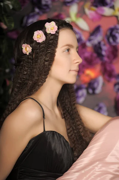 少女黑发肖像画 花朵背景下的玫瑰样式 — 图库照片