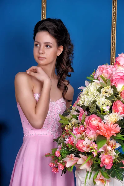 漂亮的姑娘 穿着粉红色的衣服 房间里开满了花 — 图库照片