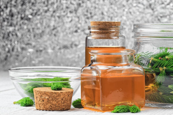 Homemade pine syrup for dry irritating throat coughs. Made from green young pine buds and honey.Alternative medicine concept on white wooden table (selective focus).