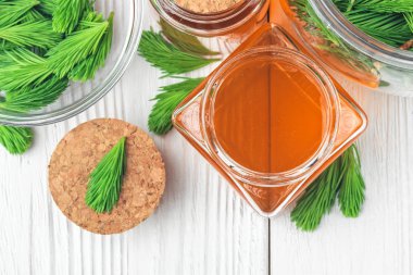 Kuru rahatsız edici boğaz öksürük için ev yapımı çam öksürük şurubu. Yeşil genç Çam tomurcukları ve bal yapılmış. Üstten görünüm (seçici odak beyaz tahta masada alternatif tıp kavramı).