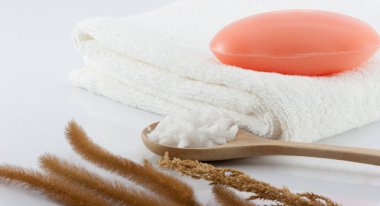 Temiz beyaz havluların üzerindeki sabun, kurutulmuş çimen ve beyaz sahnede temizlik için tuz fırçası..