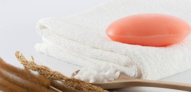 Temiz beyaz havluların üzerindeki sabun, kurutulmuş çimen ve beyaz sahnede temizlik için tuz fırçası..